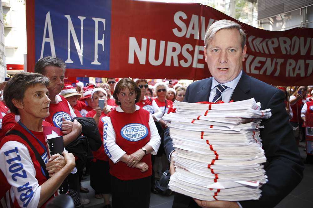 Then Victorian health minister David Davis in 2011 accepting nurses’ and midwives’ ribbon-wrapped petition – but not the message.